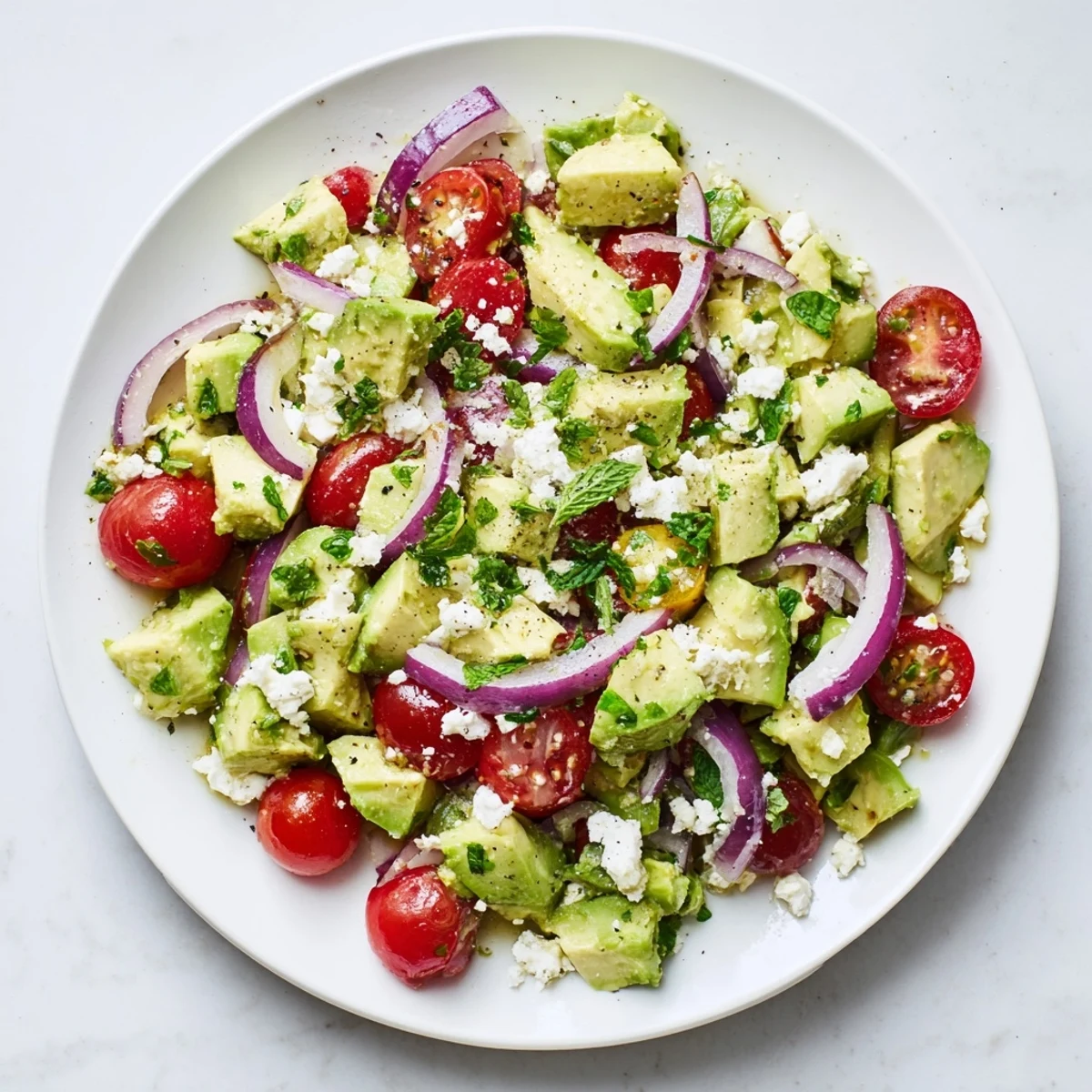 Fresh, flavorful Cucumber, Tomato, and Avocado Salad with Feta, ready to eat, a light summer meal.