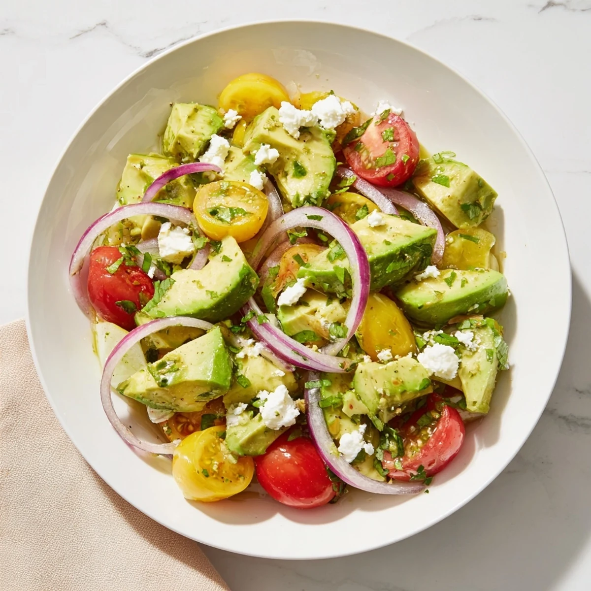 Mediterranean-style Fresh Salad: Cucumber, Tomato, and Avocado Salad with Feta, with creamy avocado and feta cheese.