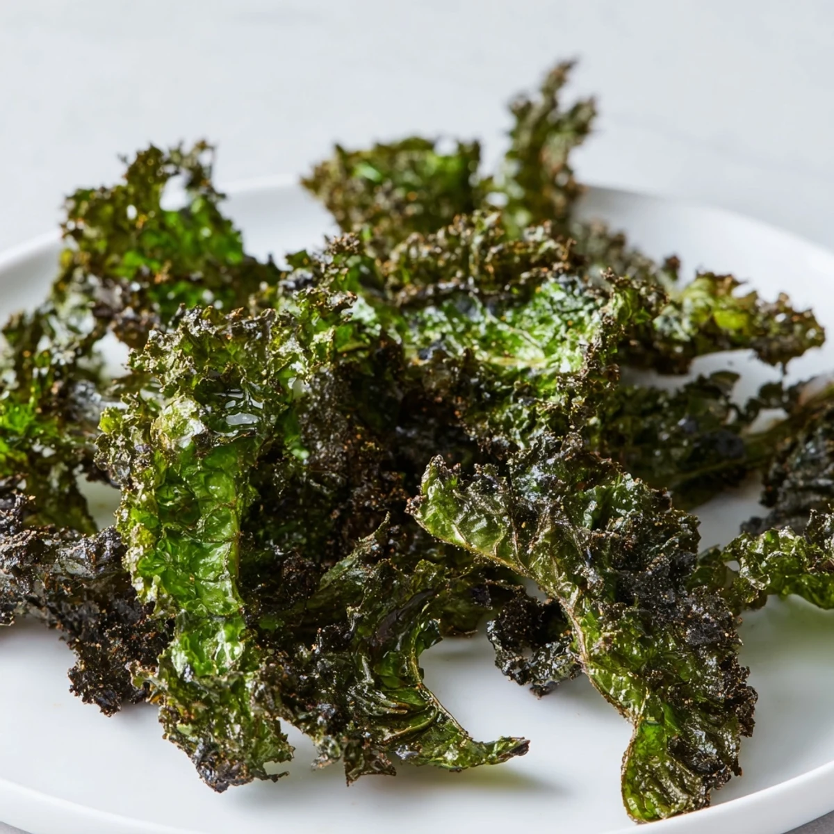 Close-up of freshly baked kale chips, showing their vibrant green color and inviting crispness.