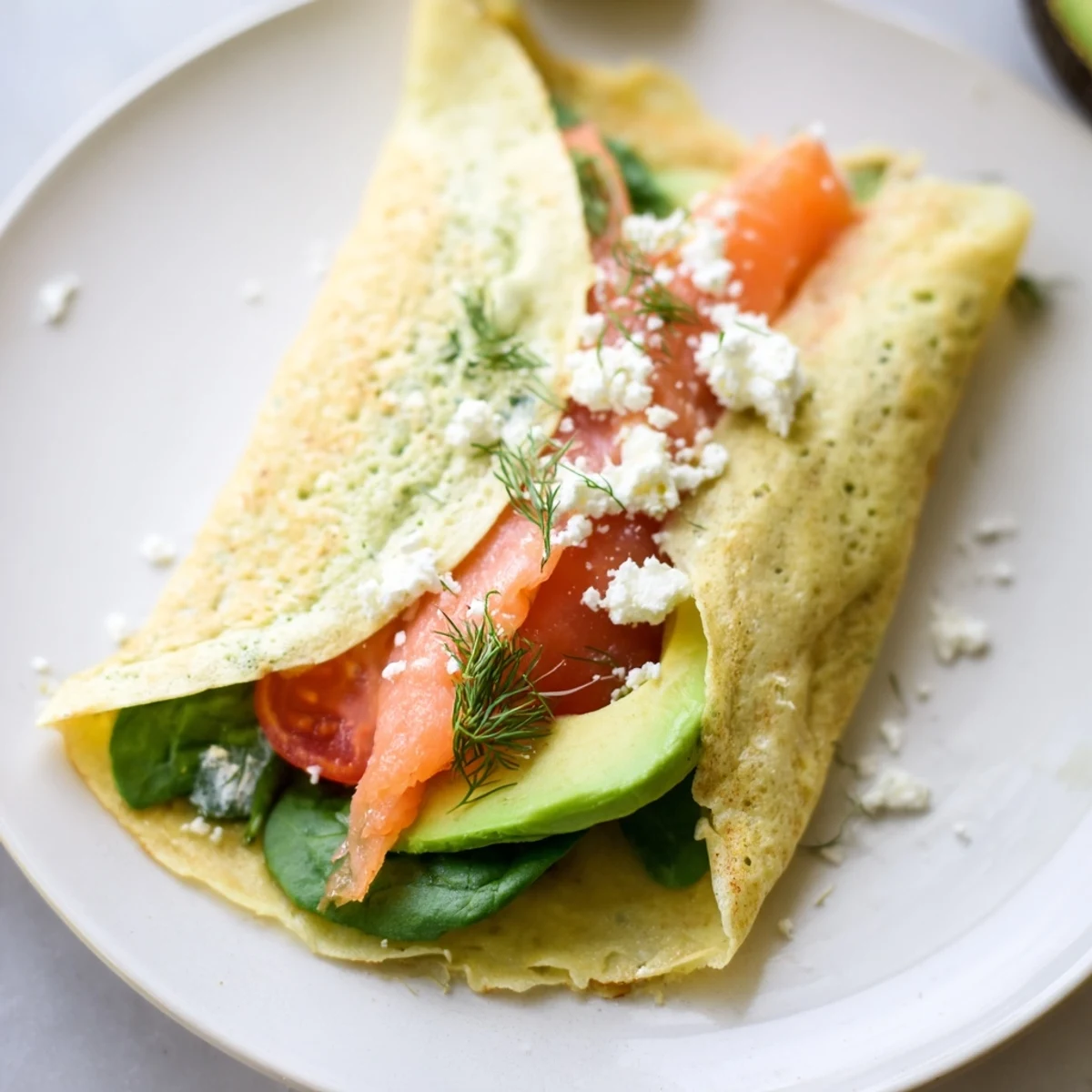 Delicate, golden Blender-Egg Crepe Wrap, filled with savory spinach and smoked salmon, ready to eat.