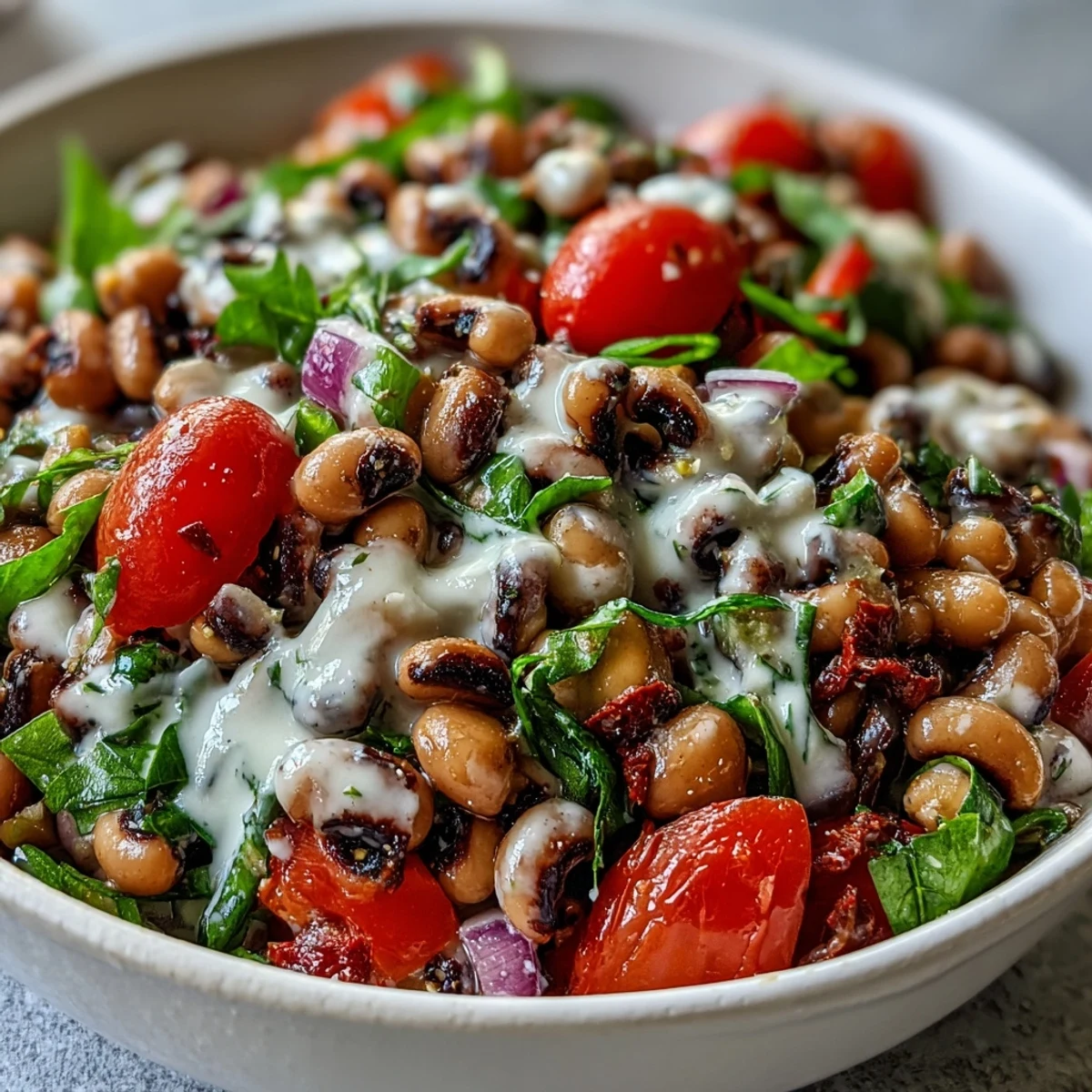 A close-up of New Years Hoppin John Salad featuring chickpeas, black-eyed peas, and tomatoes. 