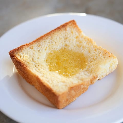 Warm, toasted sheet pan English muffins, ready to be split and topped with butter or jam.