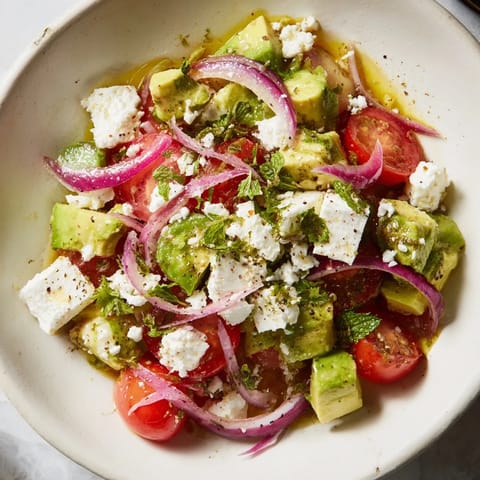 Bright, colorful close-up of Fresh Salad: Cucumber, Tomato, and Avocado Salad with Feta, perfect for a picnic.