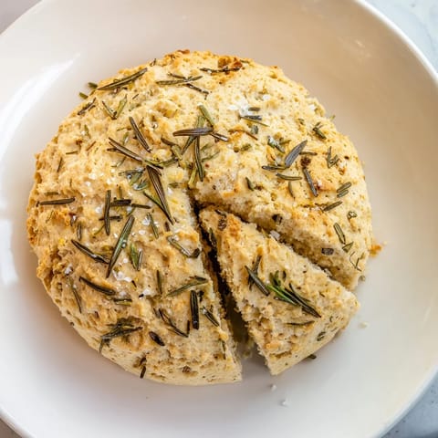 Warm, rustic Yeast-Free Garlic and Rosemary Bannock Bread, showing the scored wedges before serving with soup.