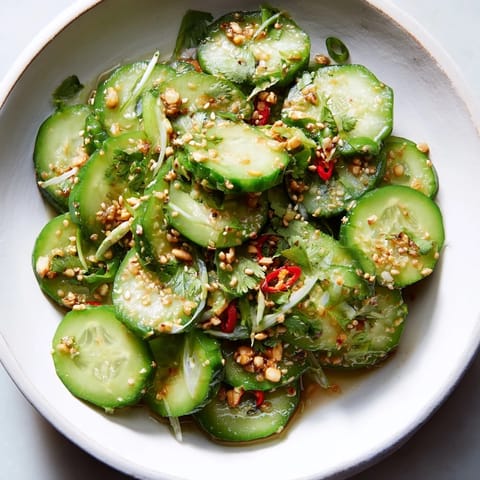 Close-up of a refreshing Tangy Shaken Asian-Style Cucumber Salad, perfect for a vegan side dish, tossed with sesame seeds.
