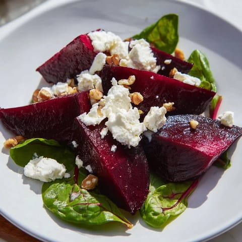 A colorful Beet and Goat Cheese Salad with roasted beet wedges, fresh greens, and crumbled goat cheese topping.