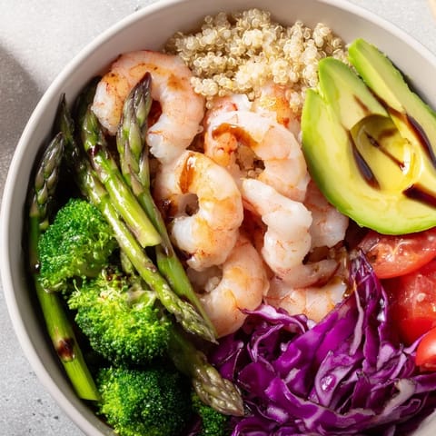 Golden sautéed shrimp and fresh vegetables top this colorful Detox Buddha Bowl with Quinoa, drizzled with balsamic vinaigrette.  
