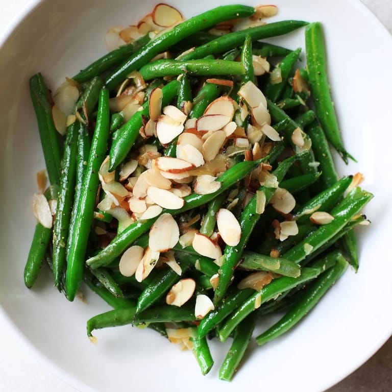 Golden, toasted almonds top the vibrant Sautéed Green Beans with garlic and pepper seasoning.