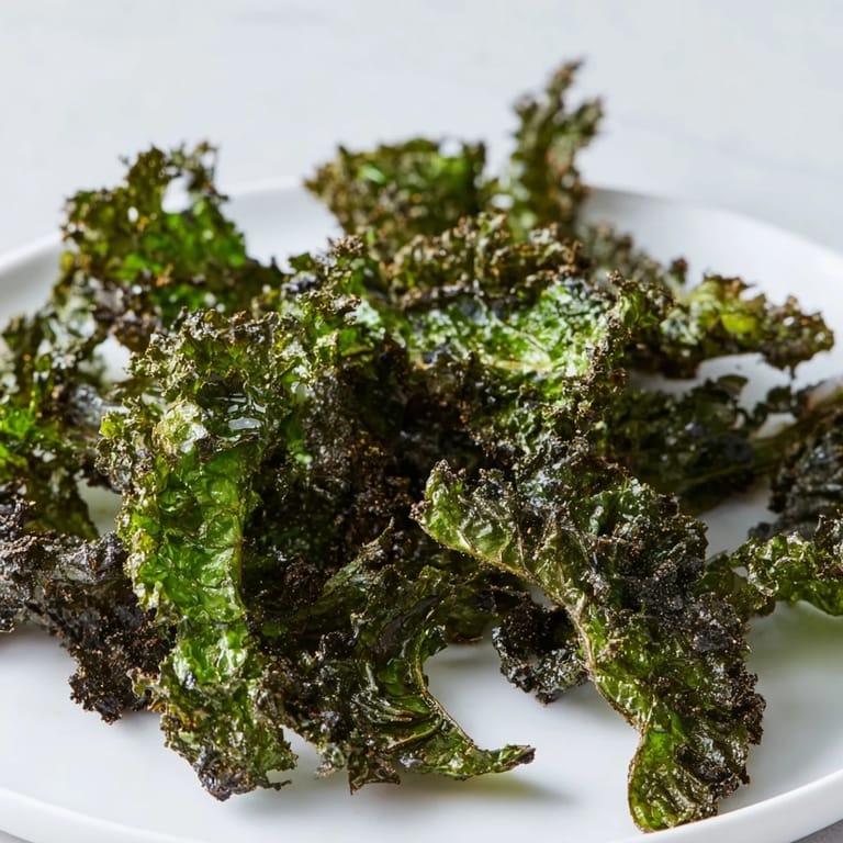 Close-up of freshly baked kale chips, showing their vibrant green color and inviting crispness.