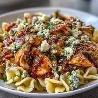 Golden-brown roasted garlic cloves and sliced herb-crusted chicken nestle with al dente penne in a savory skillet of blistered cherry tomatoes and crumbled feta.