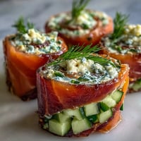 Elegant smoked salmon and cucumber cream cheese pinwheels, rolled in soft tortillas and sliced for a perfect party appetizer.