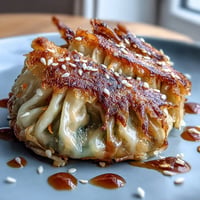 Golden pan-fried dumplings filled with savory cabbage and carrot, served with ginger soy dipping sauce. Crispy Cabbage Dumplings with golden crust and fragrant filling, perfect for appetizer or light meal. Crispy Cabbage Dumplings with tender vegetable filling, pan-fried until golden and served with zesty ginger soy sauce.
